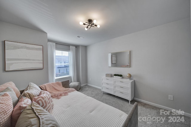 bedroom featuring light carpet and an inviting chandelier