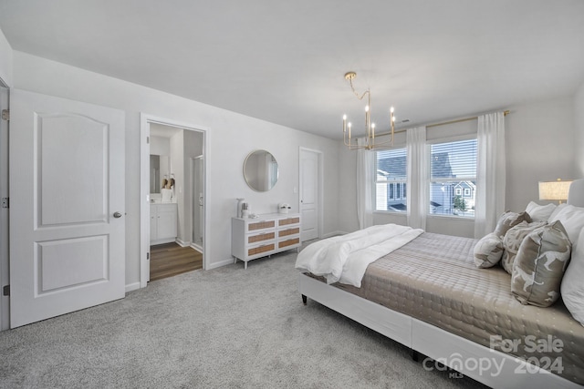 carpeted bedroom with ensuite bathroom and an inviting chandelier