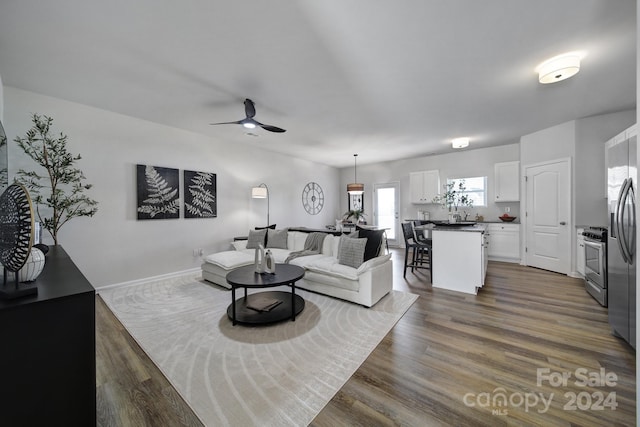 living room featuring ceiling fan and dark hardwood / wood-style flooring