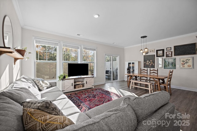 living room featuring visible vents, ornamental molding, baseboards, and wood finished floors