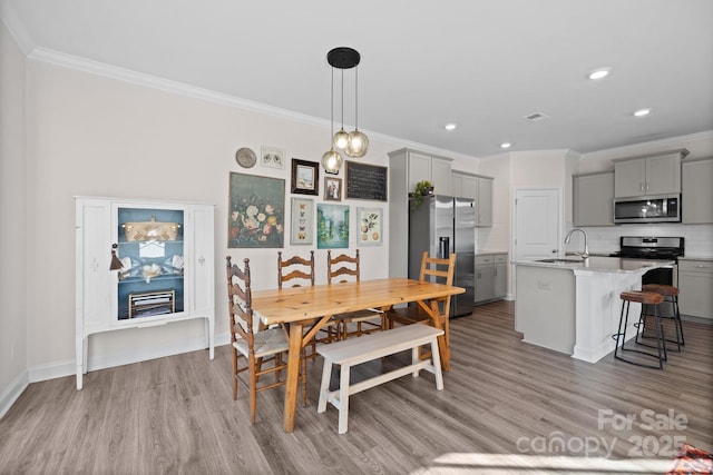 dining space with recessed lighting, visible vents, ornamental molding, and wood finished floors