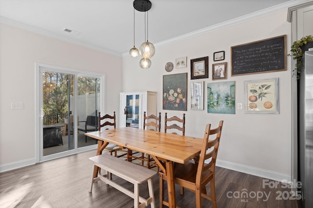 dining area featuring visible vents, baseboards, crown molding, and dark wood-type flooring