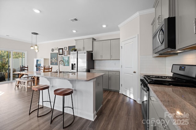 kitchen with visible vents, a sink, gray cabinetry, appliances with stainless steel finishes, and dark wood-style flooring