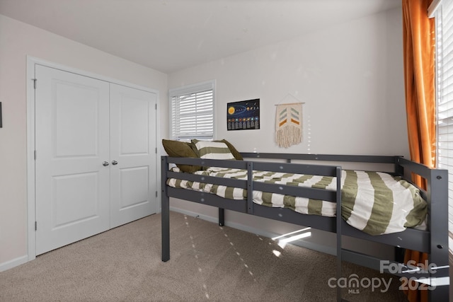 bedroom featuring a closet, baseboards, and carpet floors