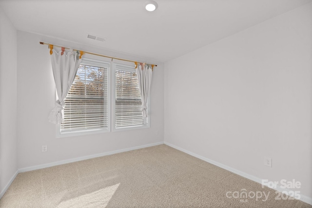 carpeted empty room with visible vents and baseboards