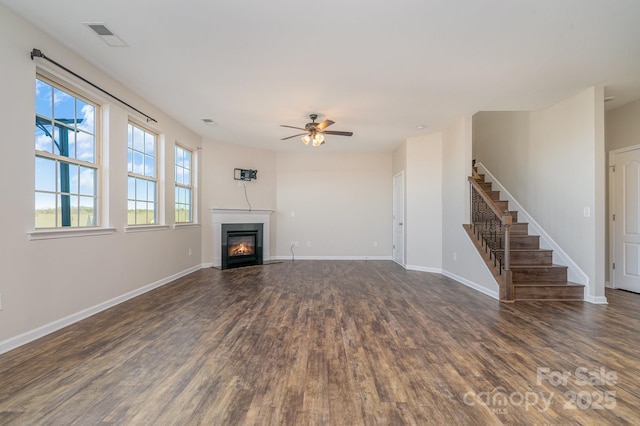 unfurnished living room featuring ceiling fan and dark wood-type flooring