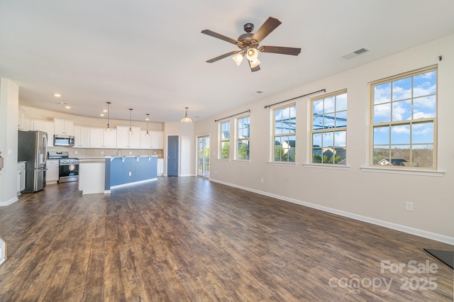 unfurnished living room with ceiling fan and dark hardwood / wood-style floors