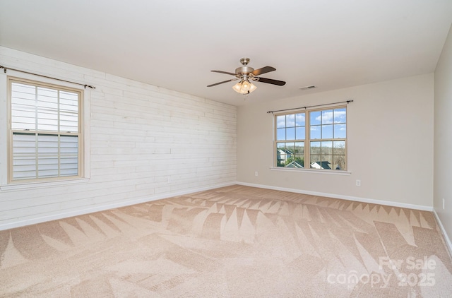 empty room with carpet flooring, ceiling fan, and brick wall