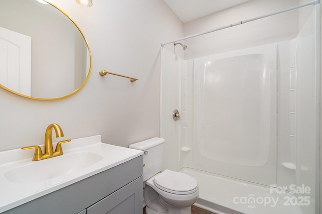 bathroom featuring vanity, toilet, and walk in shower