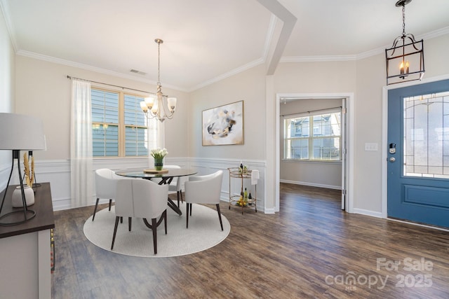 dining space featuring an inviting chandelier, dark wood-type flooring, and ornamental molding