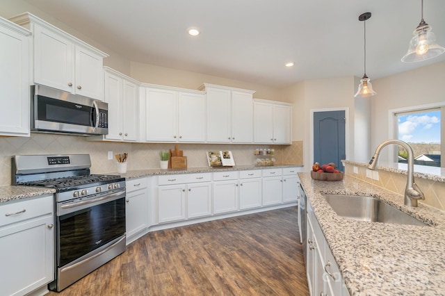 kitchen with white cabinetry, sink, pendant lighting, and appliances with stainless steel finishes