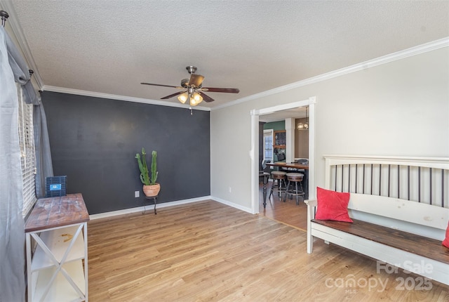 sitting room featuring ceiling fan, crown molding, a textured ceiling, and light hardwood / wood-style flooring