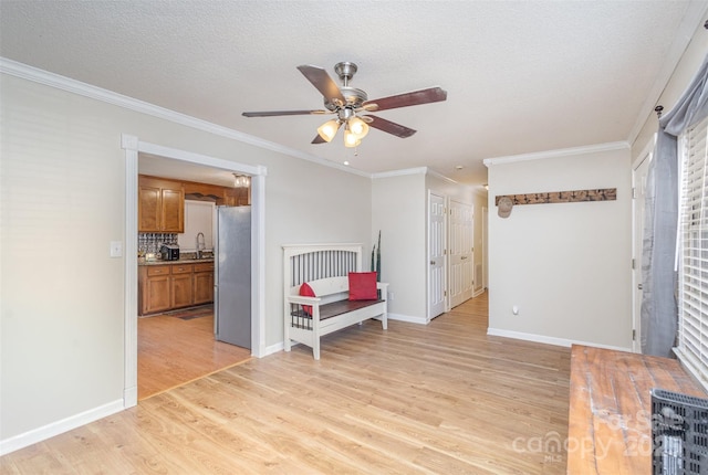 bedroom featuring stainless steel fridge, ceiling fan, ornamental molding, light hardwood / wood-style flooring, and sink