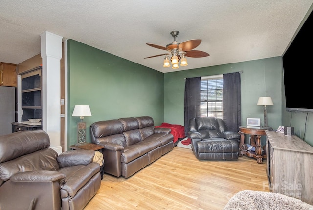 living room with ceiling fan, a textured ceiling, and light hardwood / wood-style flooring