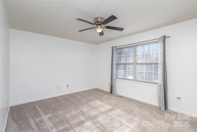 empty room featuring a textured ceiling, ceiling fan, and light colored carpet