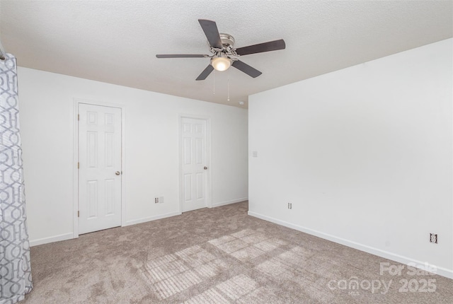 unfurnished bedroom featuring ceiling fan, light colored carpet, and a textured ceiling