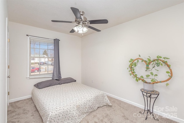 carpeted bedroom with ceiling fan and a textured ceiling