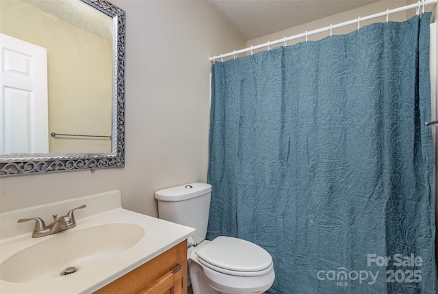 bathroom featuring toilet, vanity, and a textured ceiling