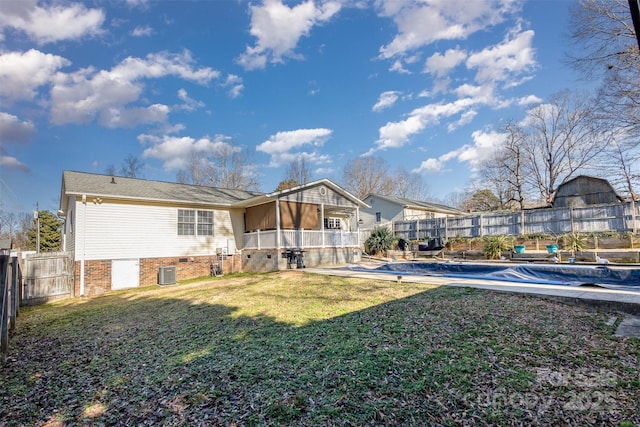 rear view of house with a covered pool, central AC, a yard, and a patio