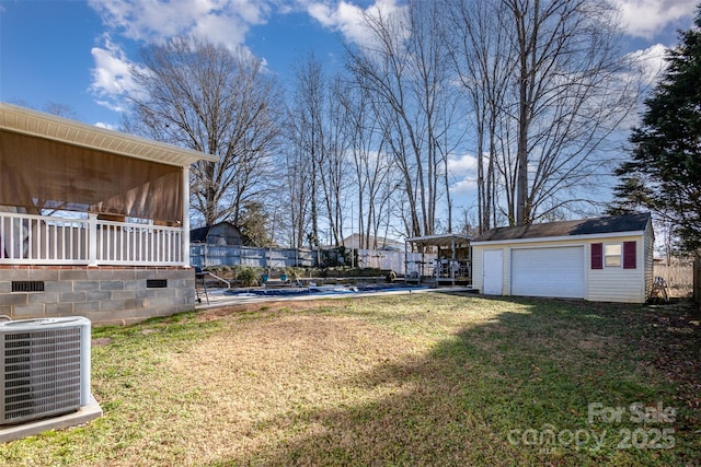 view of yard with a garage, central air condition unit, and an outbuilding