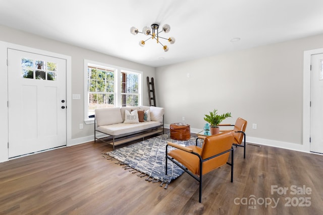 living room featuring dark hardwood / wood-style floors and an inviting chandelier