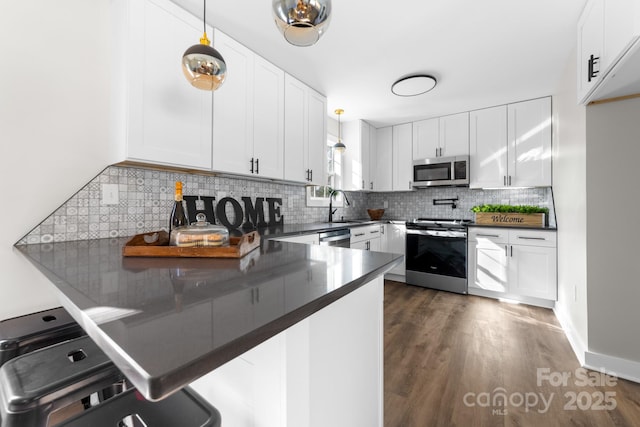 kitchen with white cabinetry, stainless steel appliances, and decorative light fixtures