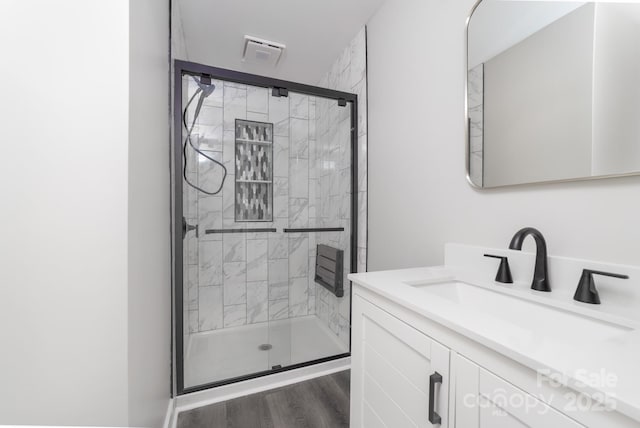 bathroom featuring walk in shower, vanity, and hardwood / wood-style flooring