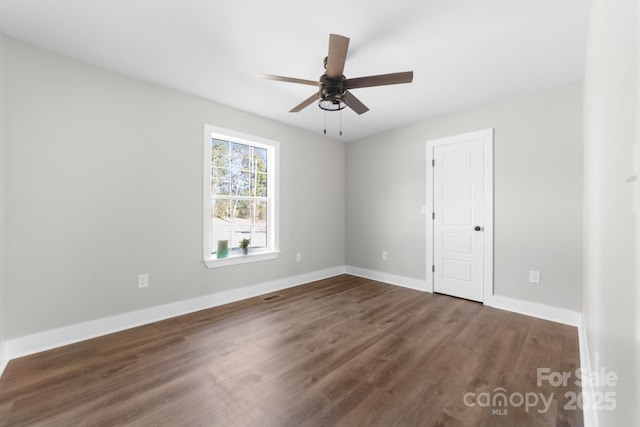 spare room featuring ceiling fan and dark wood-type flooring