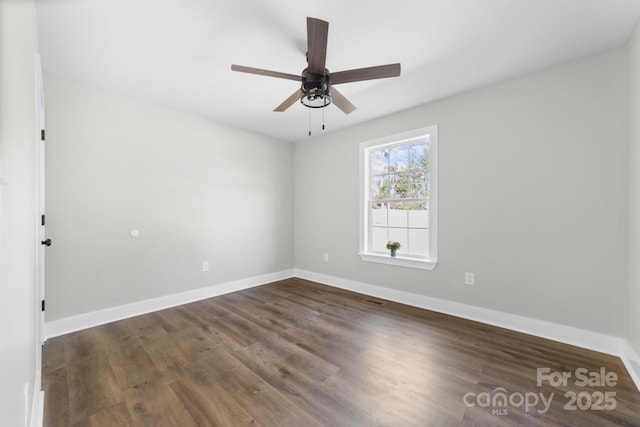 empty room with dark hardwood / wood-style floors and ceiling fan