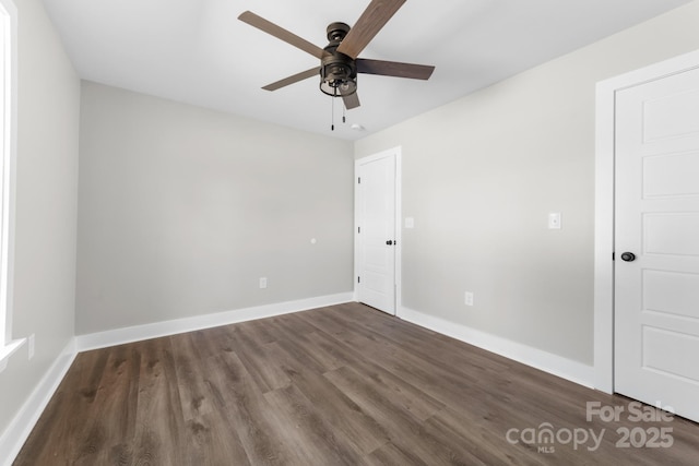 empty room with ceiling fan and dark hardwood / wood-style floors