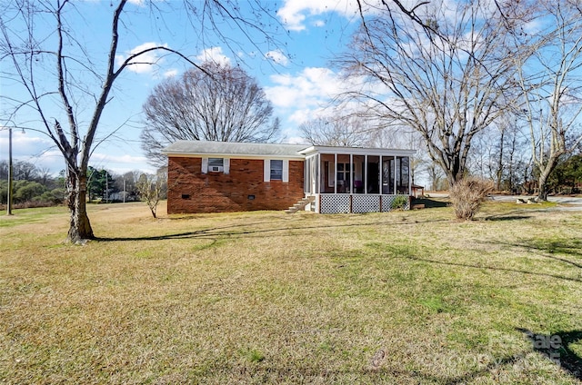 back of property with a sunroom and a lawn