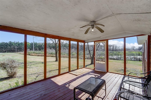 unfurnished sunroom featuring lofted ceiling, ceiling fan, and a water view