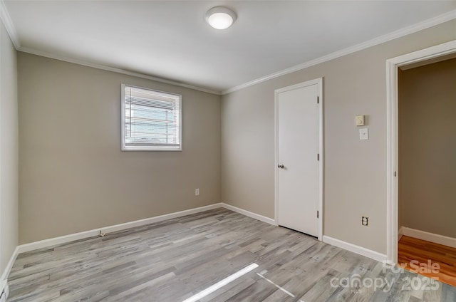 unfurnished room featuring light hardwood / wood-style floors and crown molding