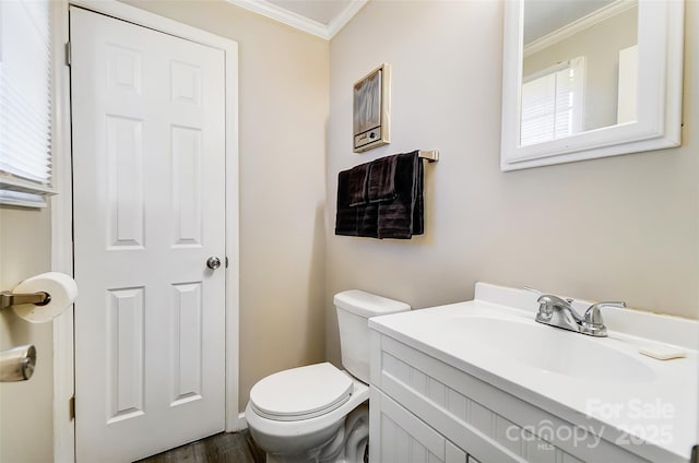 bathroom featuring toilet, plenty of natural light, crown molding, and vanity