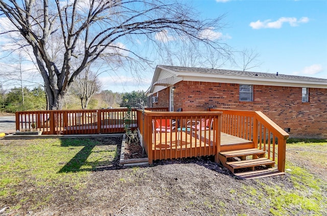 wooden terrace featuring a yard