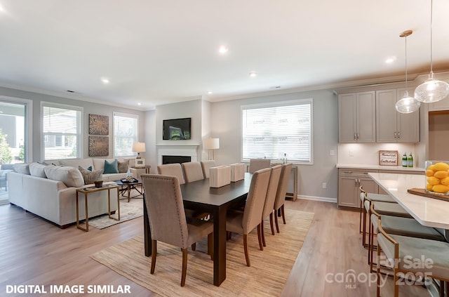 dining room with light hardwood / wood-style flooring and ornamental molding