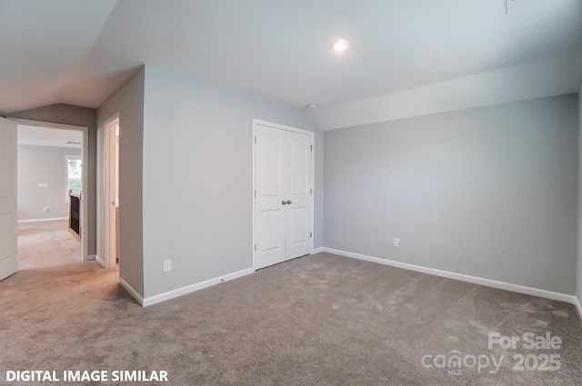 unfurnished room featuring carpet floors and vaulted ceiling