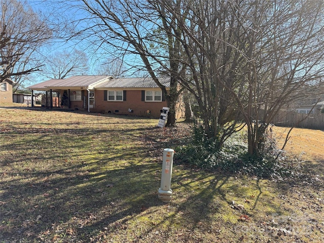 view of front of property featuring a front yard, crawl space, brick siding, and metal roof