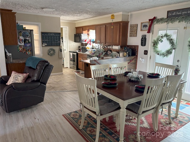 dining room featuring a textured ceiling and ornamental molding