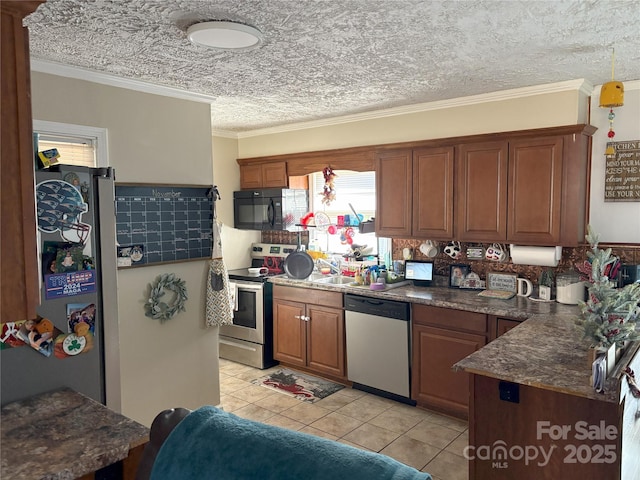 kitchen with light tile patterned floors, ornamental molding, and appliances with stainless steel finishes