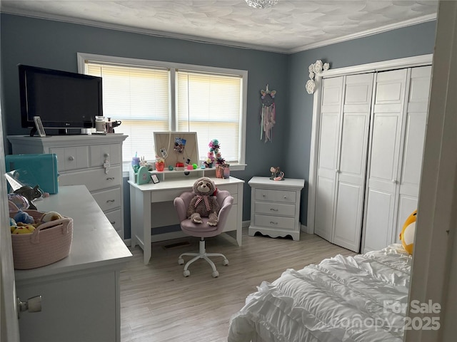 bedroom with ornamental molding, light wood-type flooring, multiple windows, and a closet