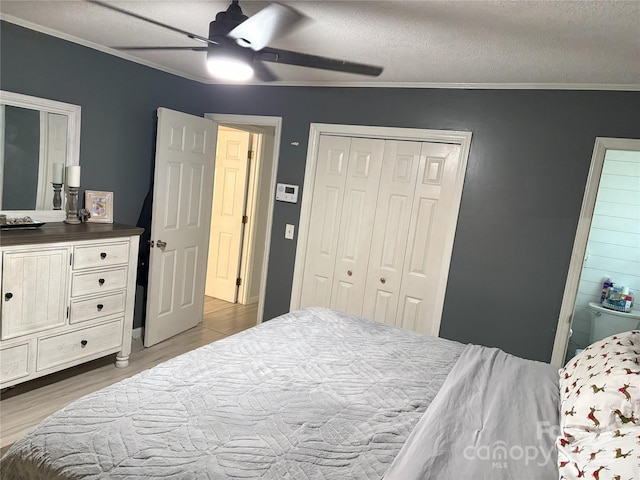 bedroom with ceiling fan, crown molding, light hardwood / wood-style floors, a textured ceiling, and a closet