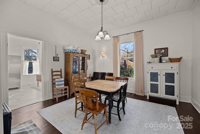 dining space with hardwood / wood-style flooring and a notable chandelier