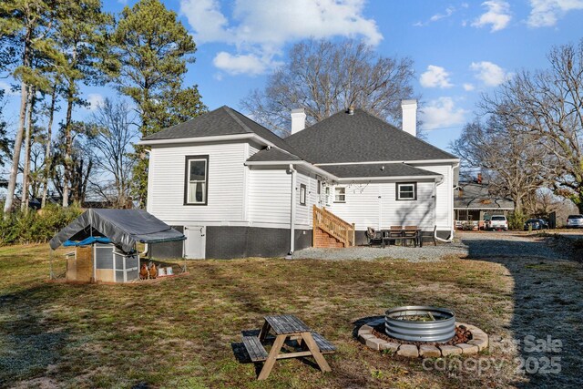 back of house featuring a fire pit and an outdoor structure