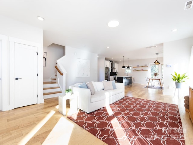 living room with light hardwood / wood-style flooring and sink