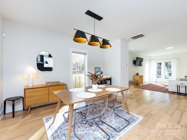 dining space with a wealth of natural light and light hardwood / wood-style flooring