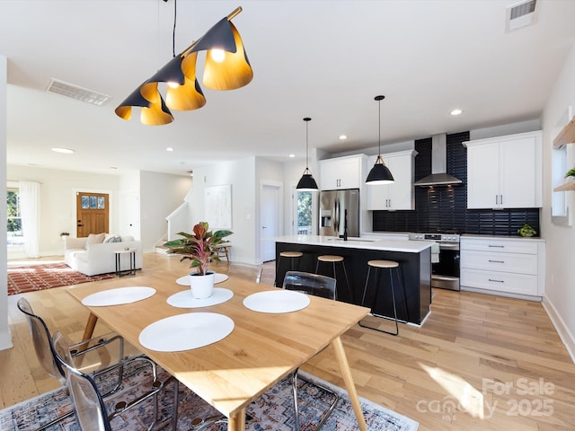 dining room featuring sink and light wood-type flooring