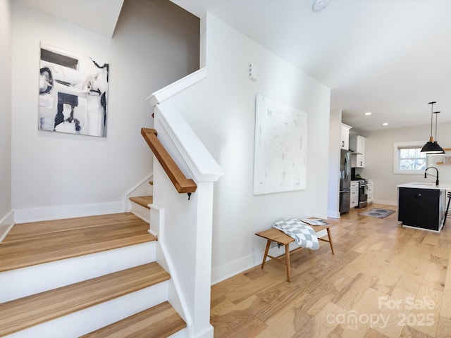 staircase featuring hardwood / wood-style flooring and sink