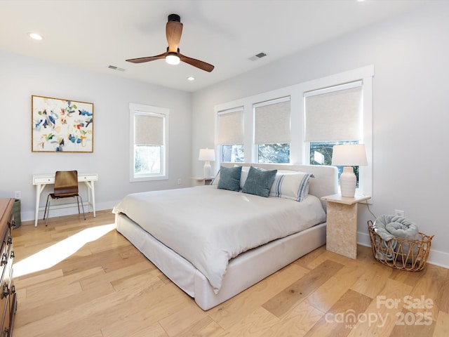 bedroom featuring multiple windows, ceiling fan, and light hardwood / wood-style flooring