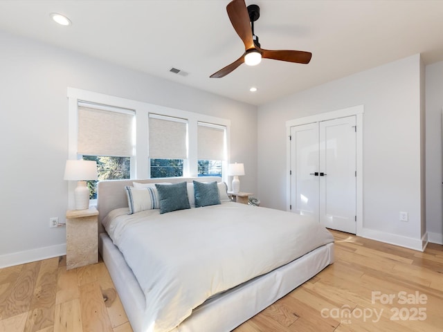 bedroom featuring ceiling fan, light wood-type flooring, and a closet